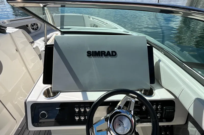 Slide: The Image of 2021 Sea Ray SLX 280 dashboard with Simrad display and steering wheel. - 47