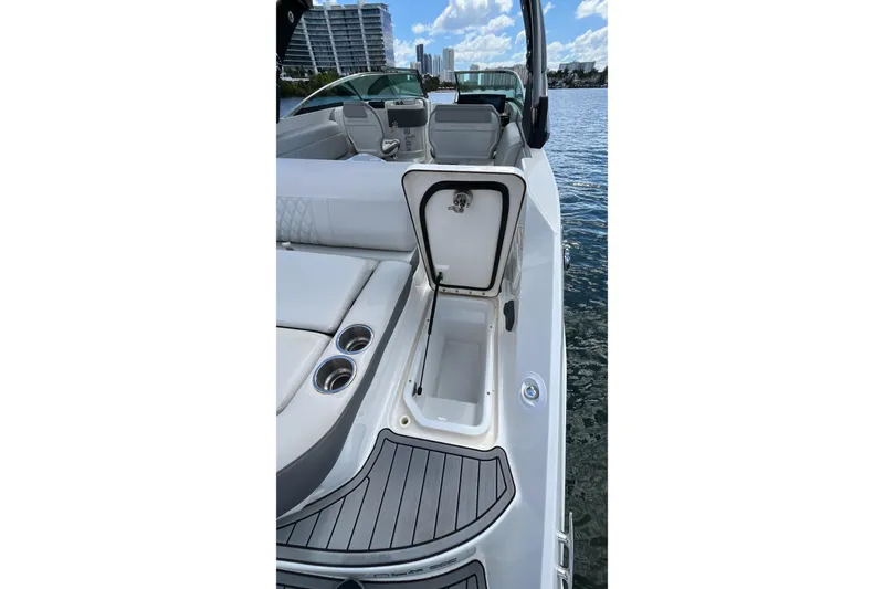 Slide: The Image of 2021 Sea Ray SLX 280 boat interior with open storage compartment and cup holders. - 55