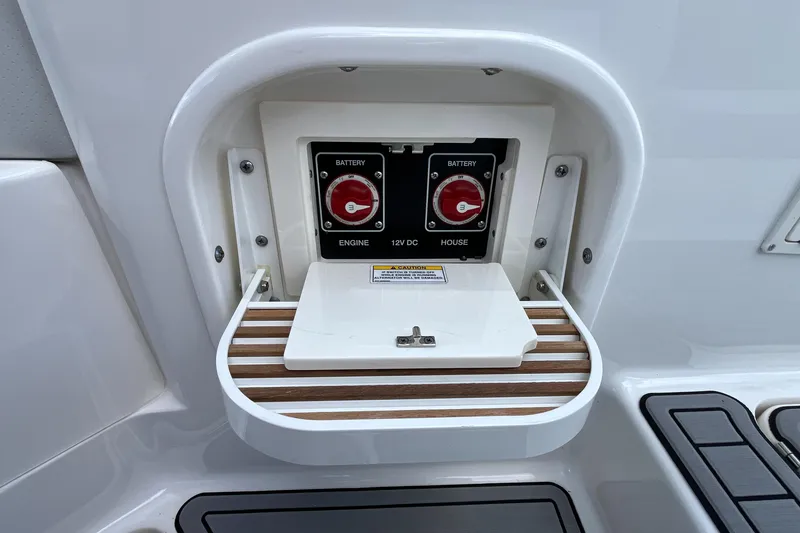 Slide: The Image of 2021 Sea Ray SLX 280 battery switches with protective cover and wood accent. - 58