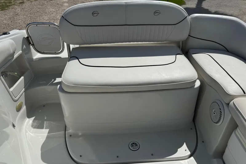 Slide: The Image of 2004 Crownline 248 BR boat interior with white cushioned seating and storage. - 10