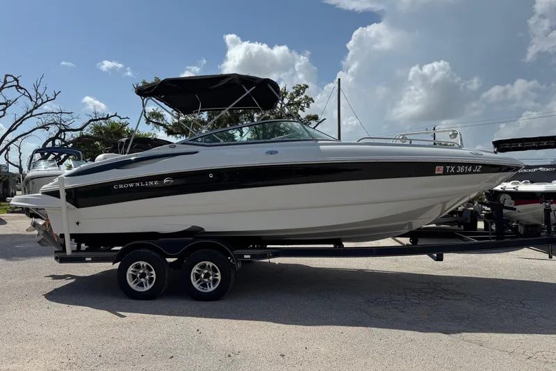 Slide: The Image of 2004 Crownline 248 BR boat on trailer under a partly cloudy sky. - 4
