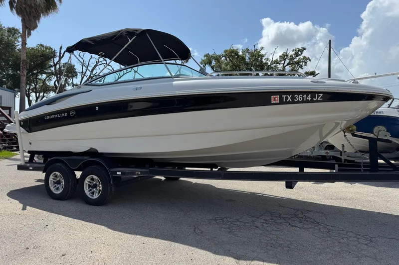 Slide: The Image of 2004 Crownline 248 BR boat on trailer, black and white design, parked outdoors. - 5