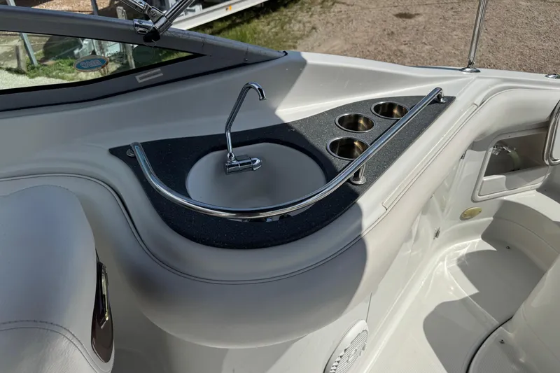 Slide: The Image of 2004 Crownline 248 BR boat interior with sink and cup holders. - 8