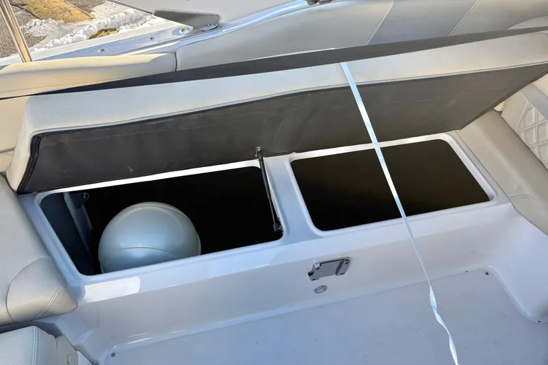 Slide: The Image of 2020 Regal 26 OBX boat storage compartment with open lid and visible interior. - 14