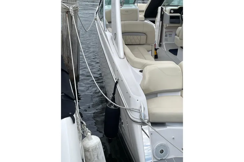 Slide: The Image of 2020 Regal 26 OBX boat docked, featuring beige seating and sleek design. - 17