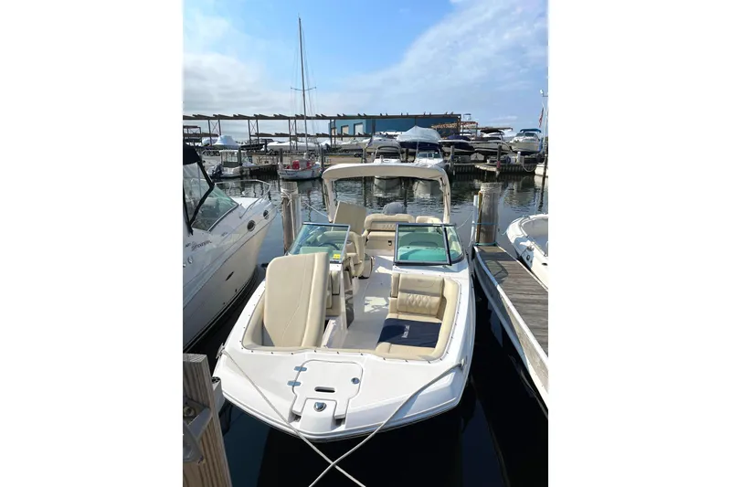 Slide: The Image of 2020 Regal 26 OBX boat docked at a marina under a partly cloudy sky. - 2