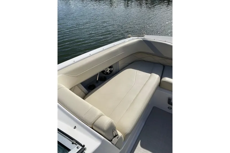 Slide: The Image of 2020 Regal 26 OBX boat interior with beige seating, on calm water. - 20
