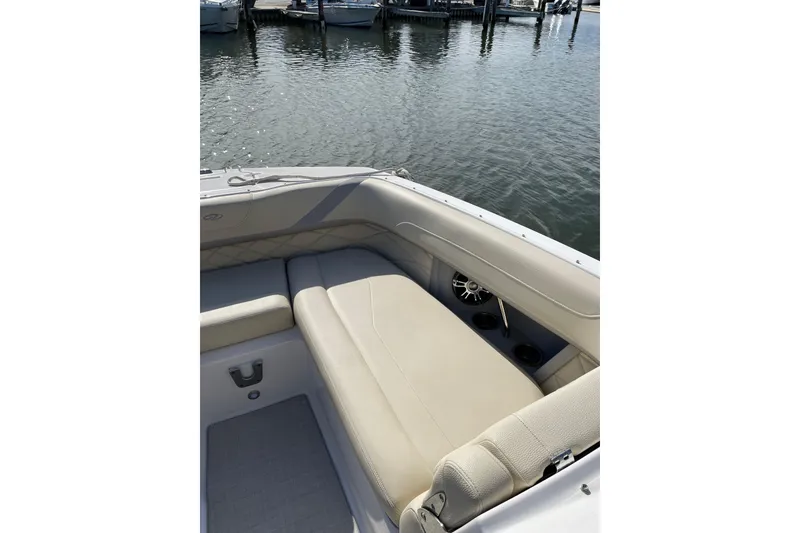 Slide: The Image of 2020 Regal 26 OBX boat interior with beige seating, docked by the water. - 21