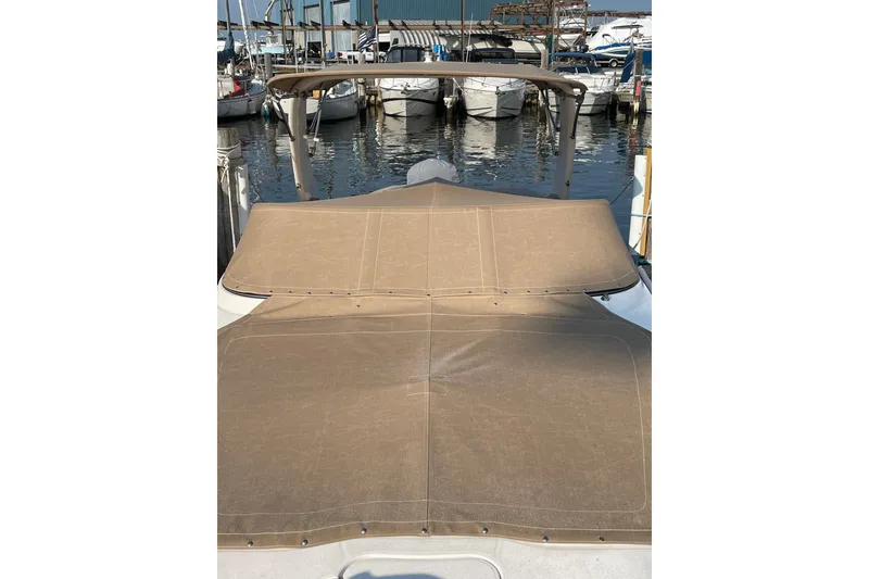 Slide: The Image of 2020 Regal 26 OBX boat with tan cover docked at marina. - 23