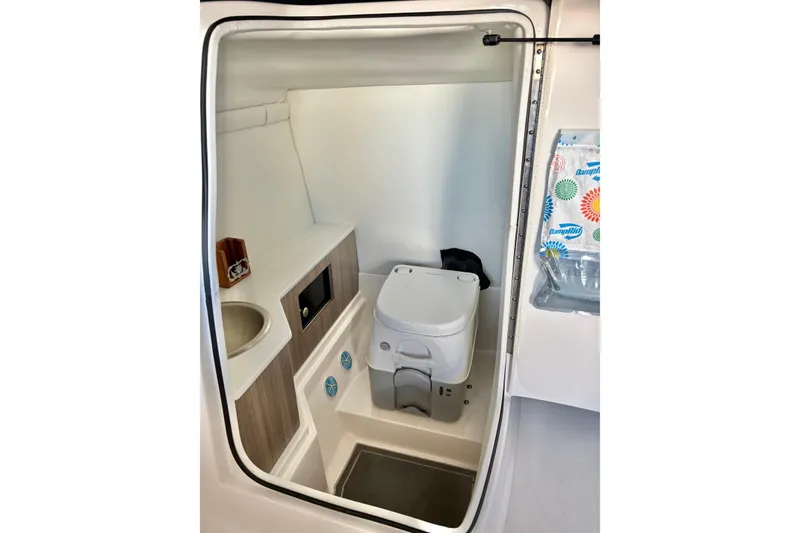 Slide: The Image of 2020 Regal 26 OBX boat interior with compact bathroom and modern amenities. - 27