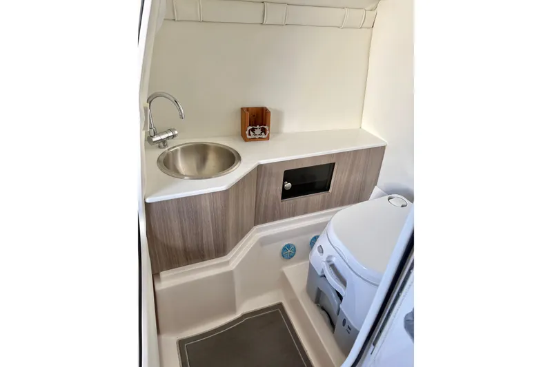 Slide: The Image of 2020 Regal 26 OBX boat interior with sink and toilet in compact bathroom. - 28
