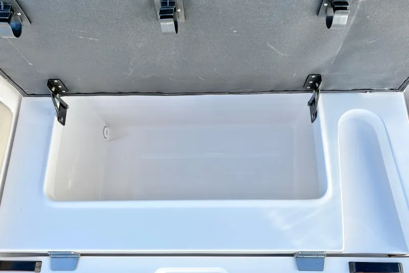 Slide: The Image of Open storage compartment in 2020 Regal 26 OBX boat, featuring durable hinges and spacious interior. - 29