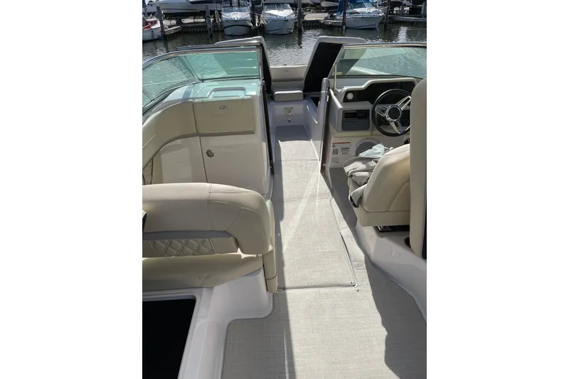 Slide: The Image of 2020 Regal 26 OBX boat interior with beige seating and steering wheel, docked at marina. - 7