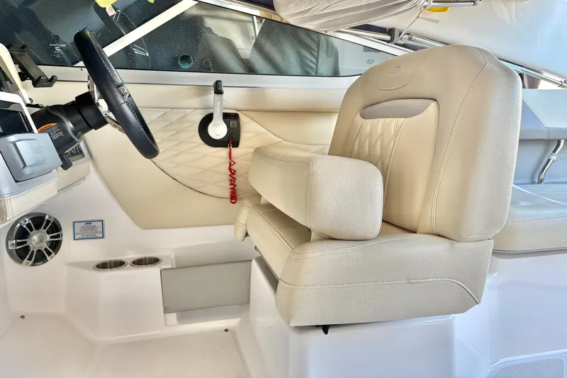 Slide: The Image of 2020 Regal 26 OBX boat interior with beige captain's seat and steering wheel. - 8