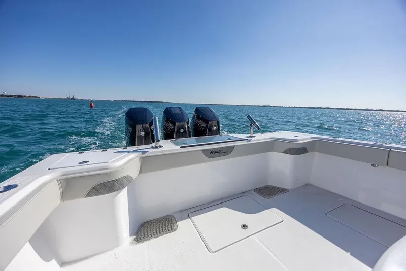 Slide: The Image of 2025 Front Runner 36 Center Console boat on open water, featuring triple outboard engines. - 15