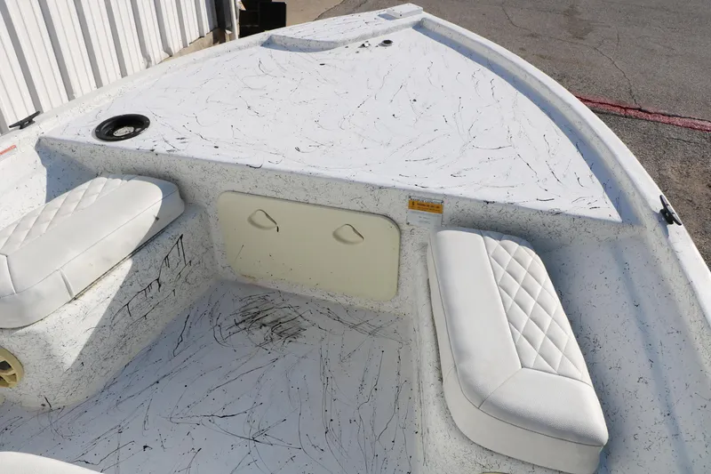 Slide: The Image of 2007 Mako 191 Inshore boat interior with white cushioned seating and storage compartments. - 17