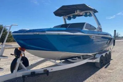 Slide: The Image of 2025 Tigé Ultré 25ZX boat on trailer, vibrant blue, sunny day. - 2