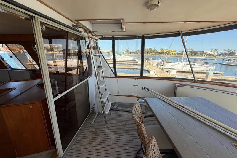 Slide: The Image of 1988 Cheoy Lee 66 Long Range MY yacht interior with marina view, featuring seating and ladder. - 40