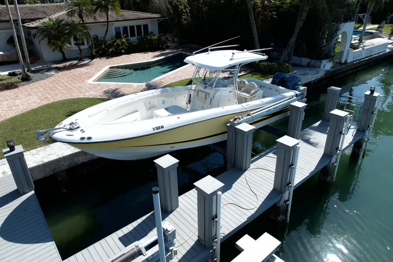 Slide: The Image of 2006 Hydra-Sports Vector 3300 CC boat docked by a waterfront home with a pool. - 3