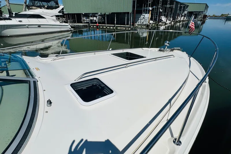 Slide: The Image of 2000 Sea Ray 290 Sundancer yacht docked at marina, featuring sleek white deck design. - 14