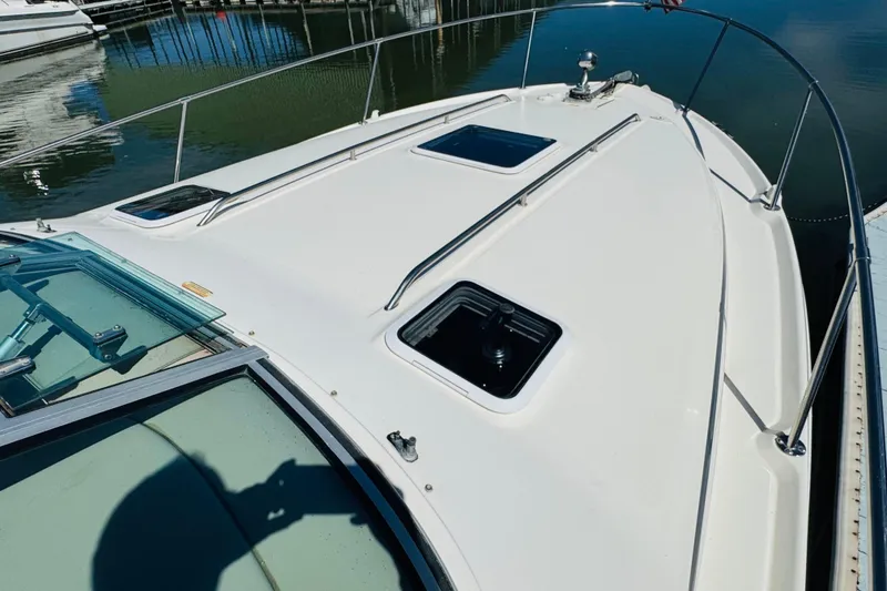 Slide: The Image of 2000 Sea Ray 290 Sundancer boat deck with hatches, docked at marina. - 16
