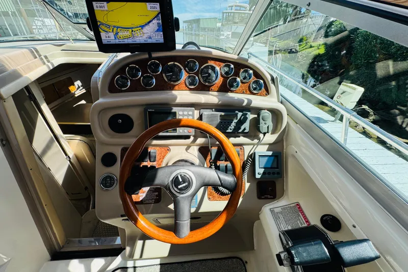 Slide: The Image of Cockpit of 2000 Sea Ray 290 Sundancer with wooden steering wheel and navigation instruments. - 22