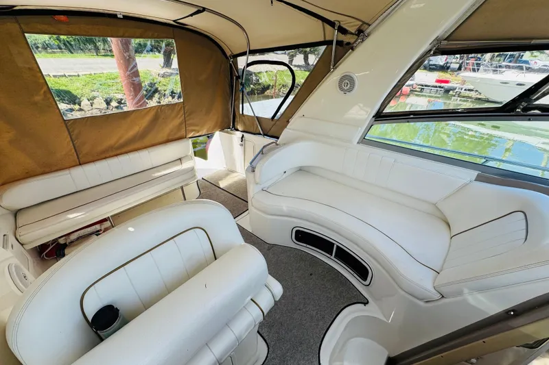 Slide: The Image of Interior of 2000 Sea Ray 290 Sundancer boat with white seating and tan canopy. - 26
