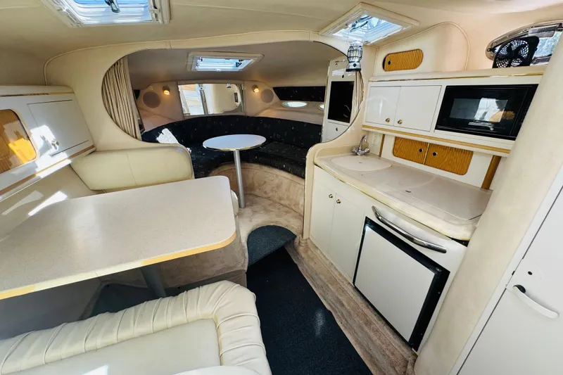Slide: The Image of Interior of 2000 Sea Ray 290 Sundancer yacht with kitchenette and seating area. - 32