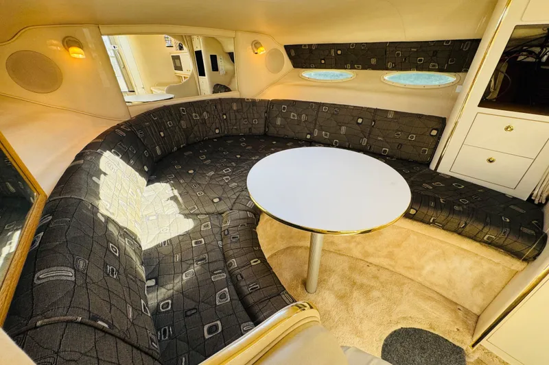 Slide: The Image of Interior of 2000 Sea Ray 290 Sundancer with curved seating and round table. - 34