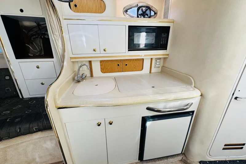 Slide: The Image of Compact galley in 2000 Sea Ray 290 Sundancer with sink, microwave, and mini-fridge. - 35