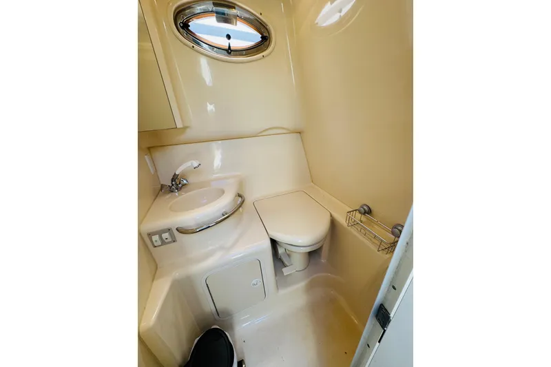 Slide: The Image of Compact bathroom in 2000 Sea Ray 290 Sundancer boat, featuring sink and toilet. - 38