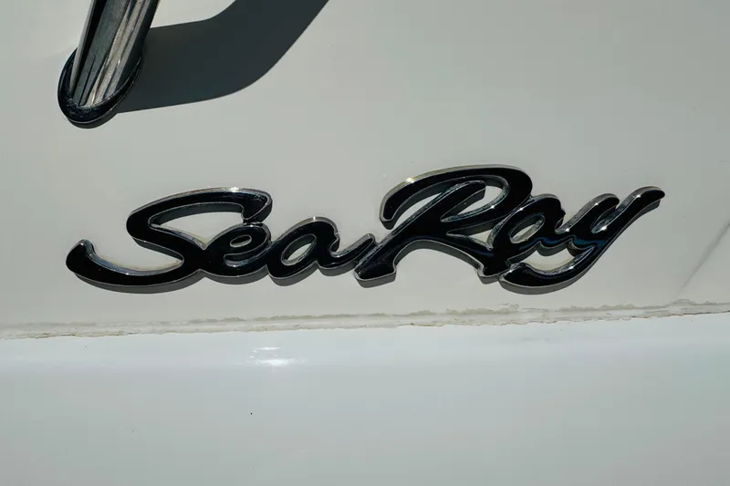 Slide: The Image of Sea Ray 290 Sundancer 2000 logo on boat exterior, chrome lettering on white surface. - 48