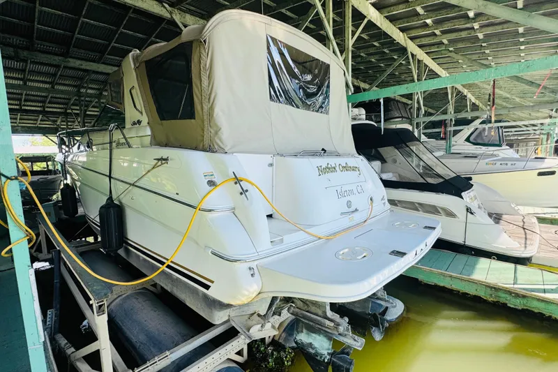 Slide: The Image of 2000 Sea Ray 290 Sundancer docked in a covered marina, rear view. - 5
