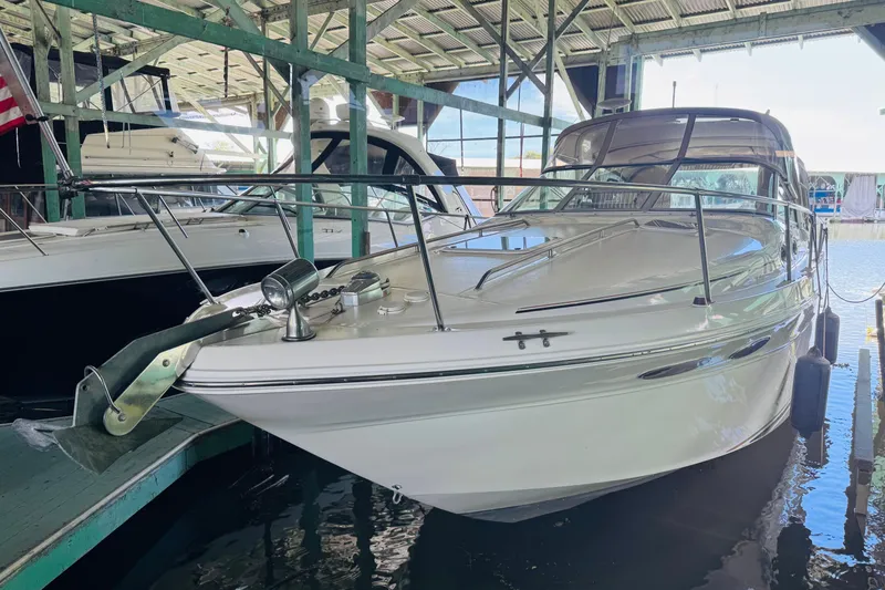 Slide: The Image of 2000 Sea Ray 290 Sundancer docked in a covered marina, showcasing sleek design and polished exterior. - 7