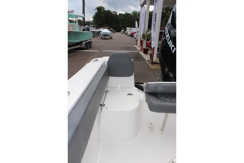 Slide: The Image of 2024 Clearwater 2300 CC boat interior with seating and Suzuki engine in a dealership. - 12