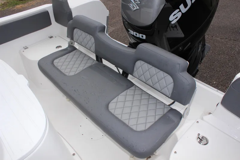 Slide: The Image of 2024 Clearwater 2300 CC boat with gray cushioned seating and powerful outboard motor. - 15