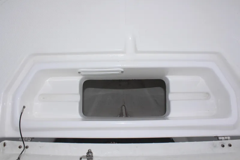 Slide: The Image of 2024 Clearwater 2300 CC boat storage compartment, white interior, open hatch. - 27