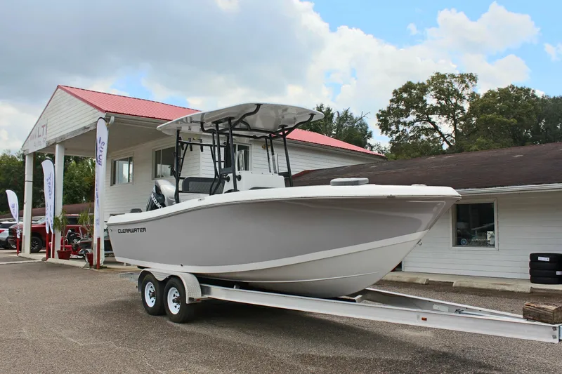 Slide: The Image of 2024 Clearwater 2300 CC boat on trailer outside dealership, under cloudy sky. - 4