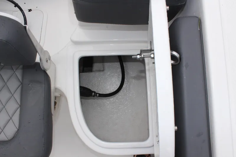 Slide: The Image of 2024 Clearwater 2300 CC boat interior storage compartment with seating detail. - 14