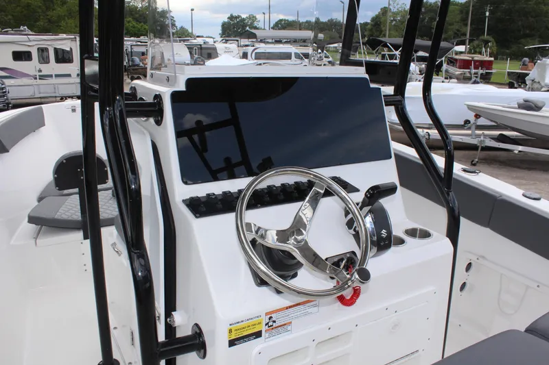 Slide: The Image of 2024 Clearwater 2300 CC boat console with steering wheel and controls. - 16