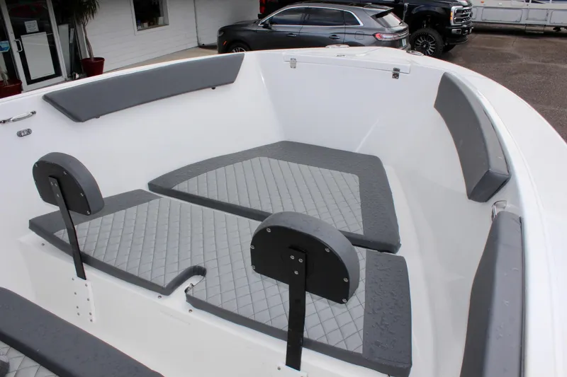 Slide: The Image of 2024 Clearwater 2300 CC boat interior with gray seating and cushions. - 24