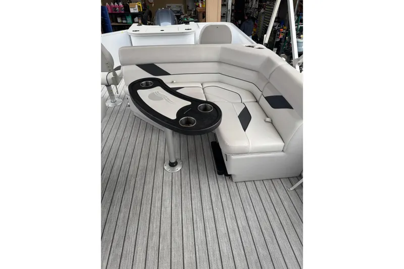 Slide: The Image of 2022 G3 Suncatcher Select 322RF boat interior with cushioned seating and table. - 15