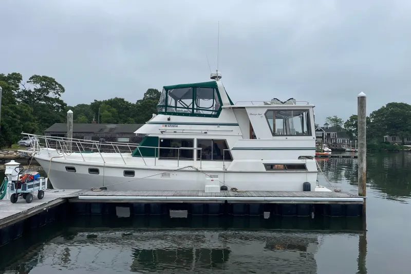 The Image of 1987 Heritage East 40 Sundeck yacht docked at marina, overcast sky. - 0