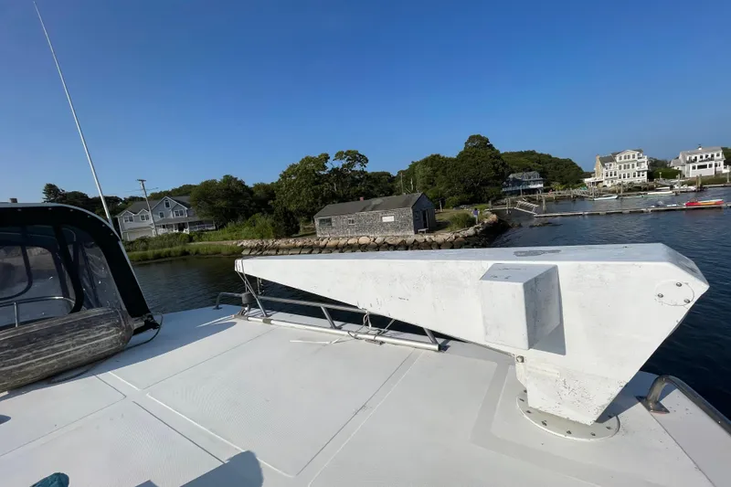 Slide: The Image of 1987 Heritage East 40 Sundeck yacht docked near waterfront homes and lush greenery. - 10