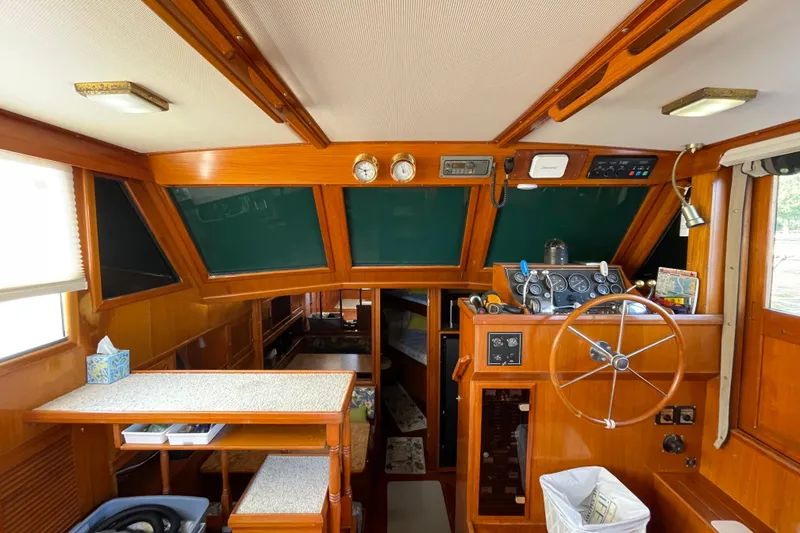 Slide: The Image of 1987 Heritage East 40 Sundeck interior with wooden helm, steering wheel, and navigation instruments. - 13