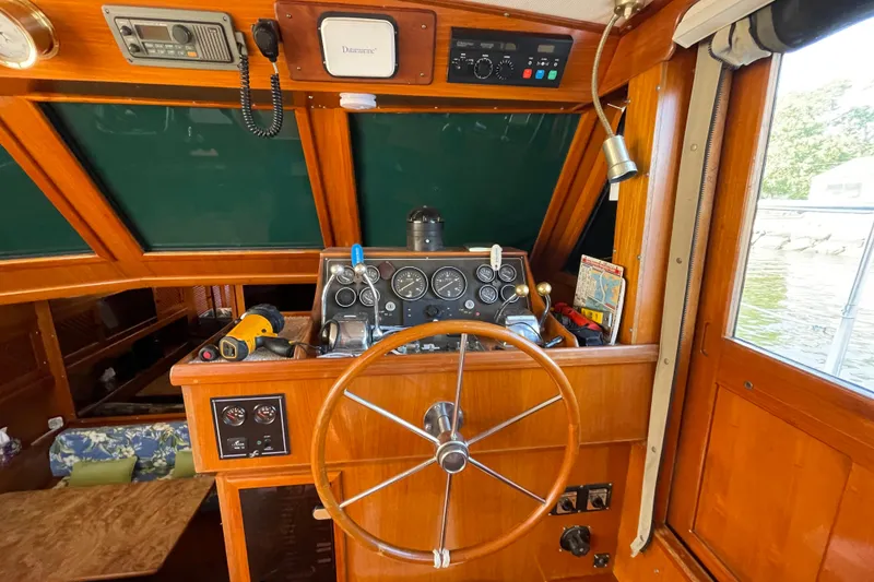 Slide: The Image of 1987 Heritage East 40 Sundeck helm with wooden wheel and navigation instruments. - 14