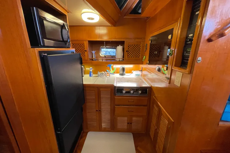 Slide: The Image of 1987 Heritage East 40 Sundeck yacht kitchen with wooden cabinetry, stove, and appliances. - 15