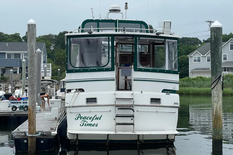 Slide: The Image of 1987 Heritage East 40 Sundeck yacht docked, named "Peaceful Times," with green trim. - 2