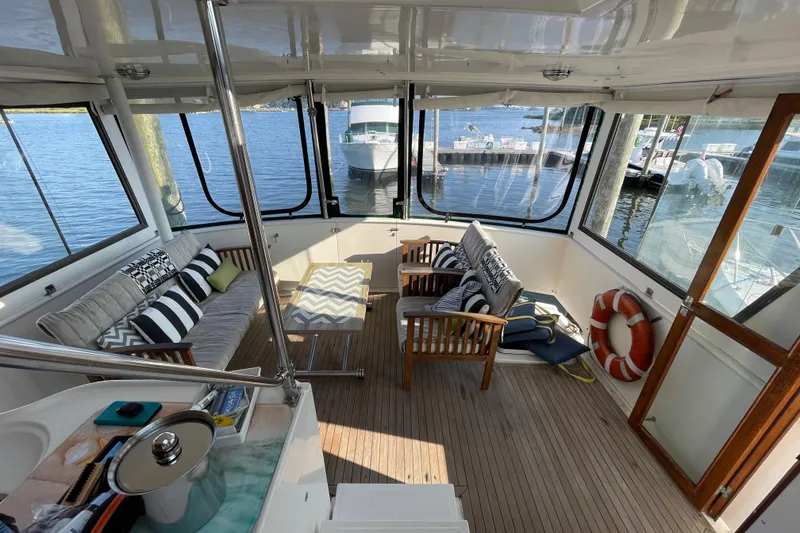 Slide: The Image of 1987 Heritage East 40 Sundeck interior with cozy seating and waterfront view. - 3