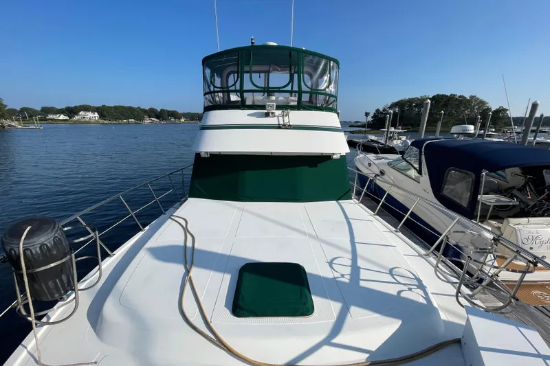 Slide: The Image of 1987 Heritage East 40 Sundeck yacht docked at marina, featuring spacious deck and green canopy. - 31